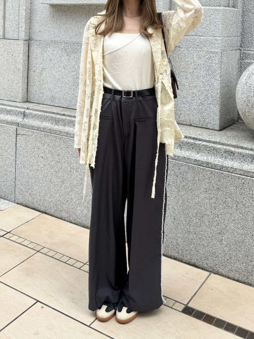 ホワイト系のテーラードジャケット、ブラウン系のショルダーバッグ、グレー系のスラックスを着用したレディースの秋コーディネートの3枚目の写真