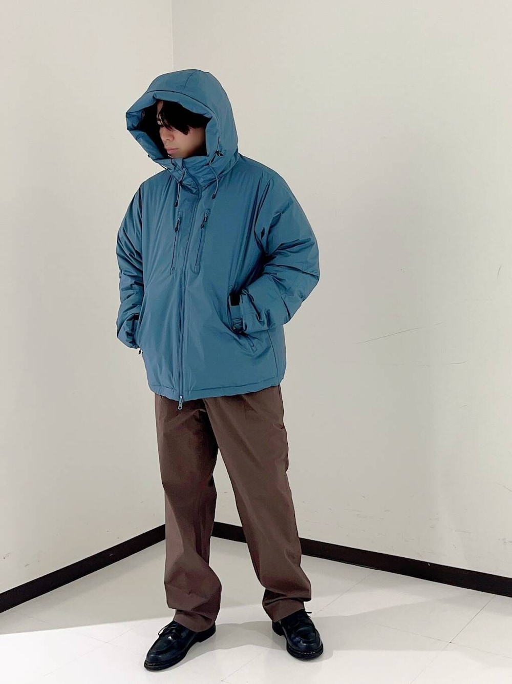 ブラウン系のその他パンツ、ブルー系のダウンジャケット/コートを着用したメンズの秋コーディネートの2枚目の写真