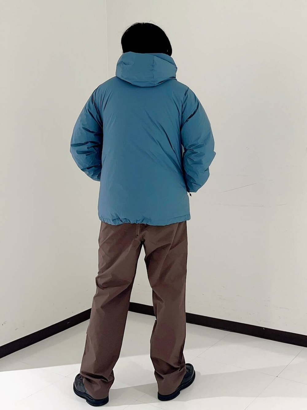 ブラウン系のその他パンツ、ブルー系のダウンジャケット/コートを着用したメンズの秋コーディネートの3枚目の写真