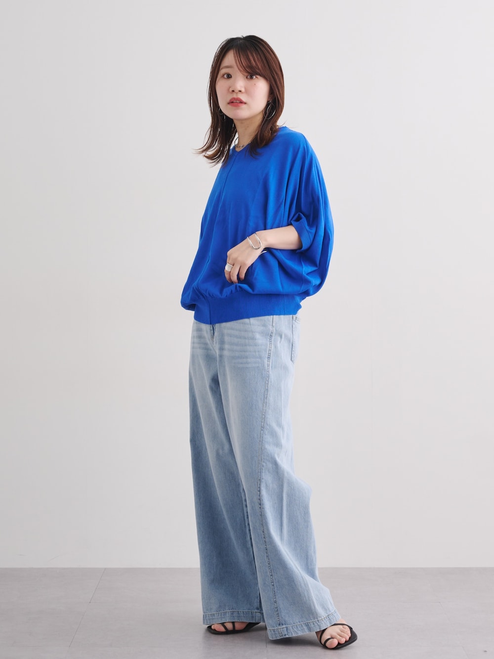 ブルー系のデニムパンツ、ブルー系のニット/セーター、ブルー系のデニムパンツを着用したレディースの春コーディネートの2枚目の写真