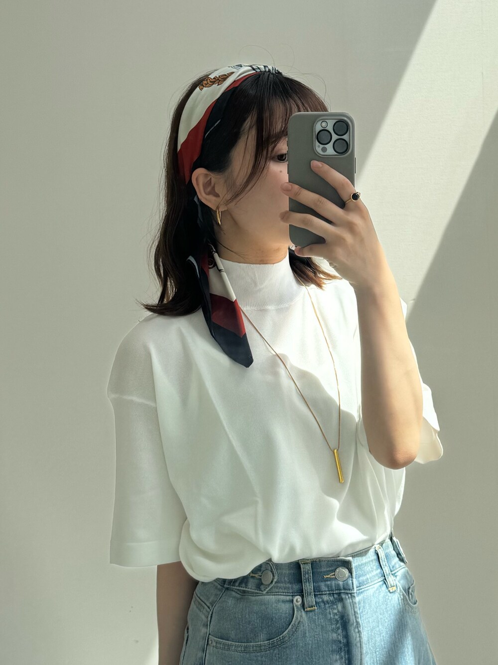 ブルー系のデニムパンツ、ホワイト系のニット/セーター、ブルー系のデニムパンツを着用したレディースの春コーディネートの2枚目の写真