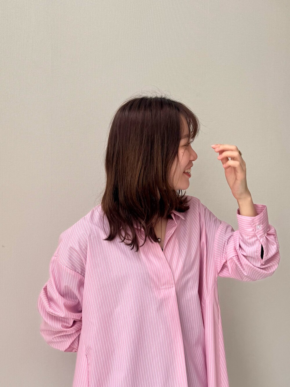 ピンク系のシャツワンピース、ピンク系のシャツワンピース、グレー系のデニムパンツを着用したレディースの春コーディネートの2枚目の写真