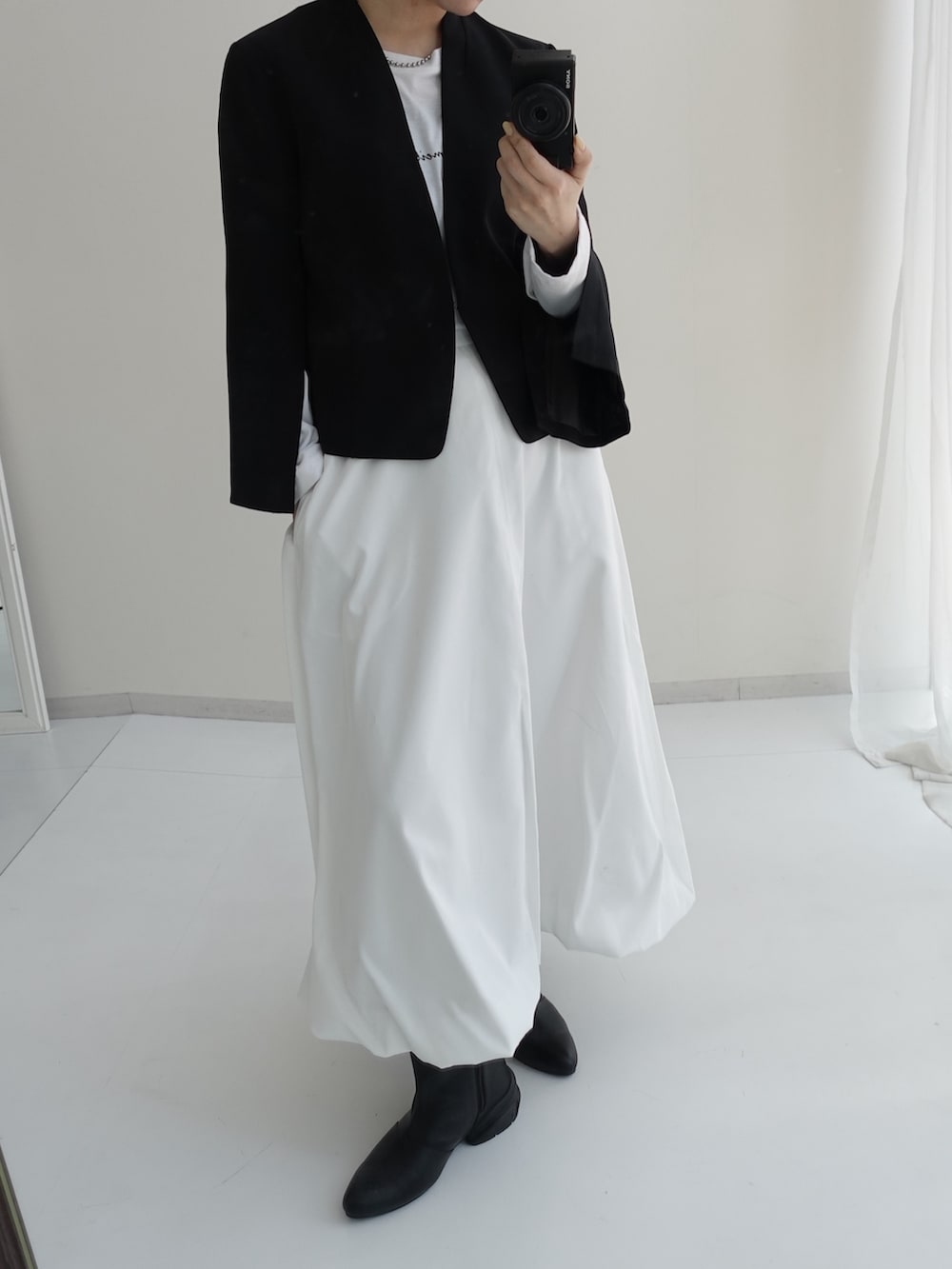 ブラック系のスーツセット、ブラック系のスーツセット、ホワイト系のスカートを着用したレディースの冬コーディネートの2枚目の写真