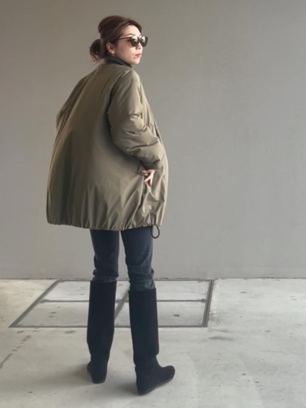 ブラック系のブーツ、グリーン系のその他アウターを着用したレディースの冬コーディネートの2枚目の写真