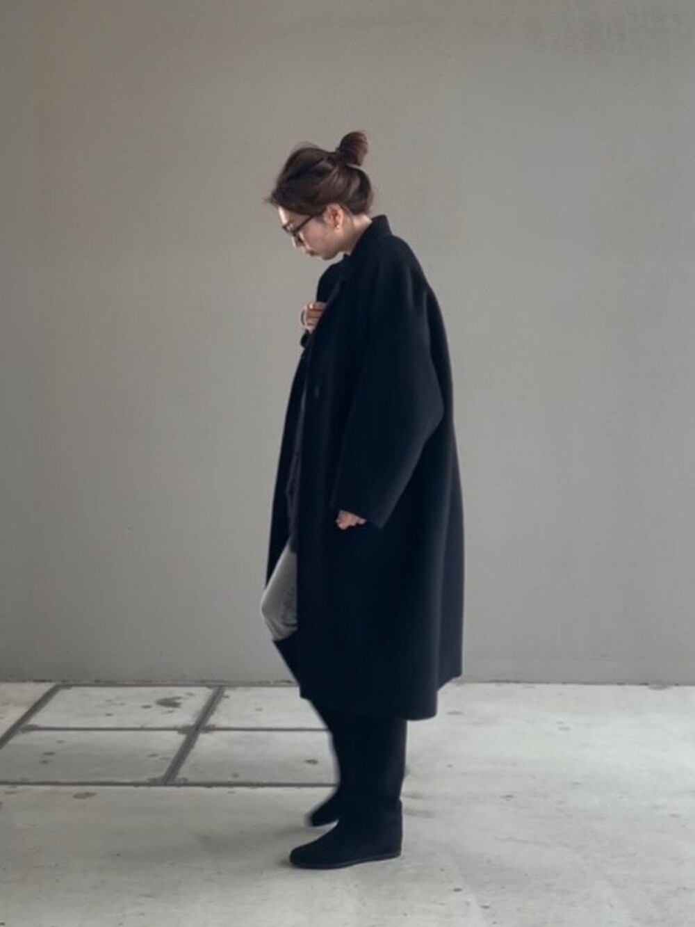 ブラック系のTシャツ/カットソー、ブラック系のカーディガン/ボレロ、ブラック系のブーツを着用したレディースの冬コーディネートの3枚目の写真