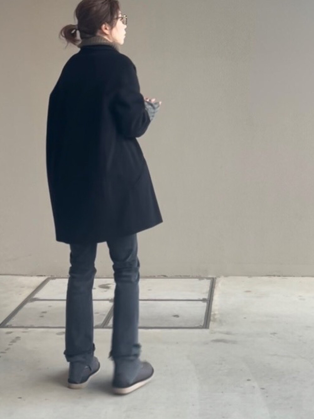 ブラック系のデニムパンツ、ブラック系のその他アウター、ブラウン系のニット/セーターを着用したレディースの冬コーディネートの2枚目の写真