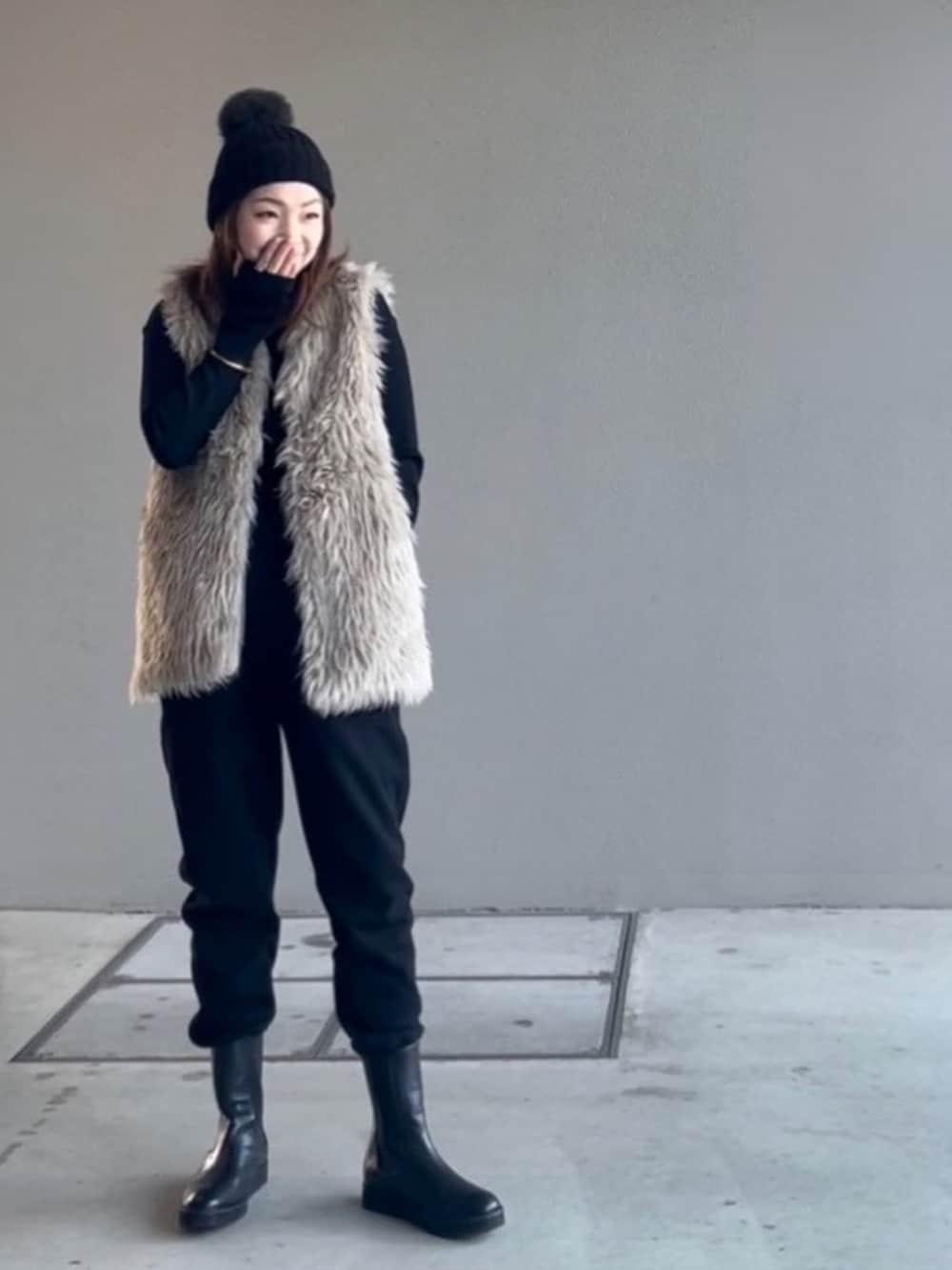 ベージュ系のベスト、ブラック系のブーツ、ブラック系のTシャツ/カットソーを着用したレディースの冬コーディネートの2枚目の写真