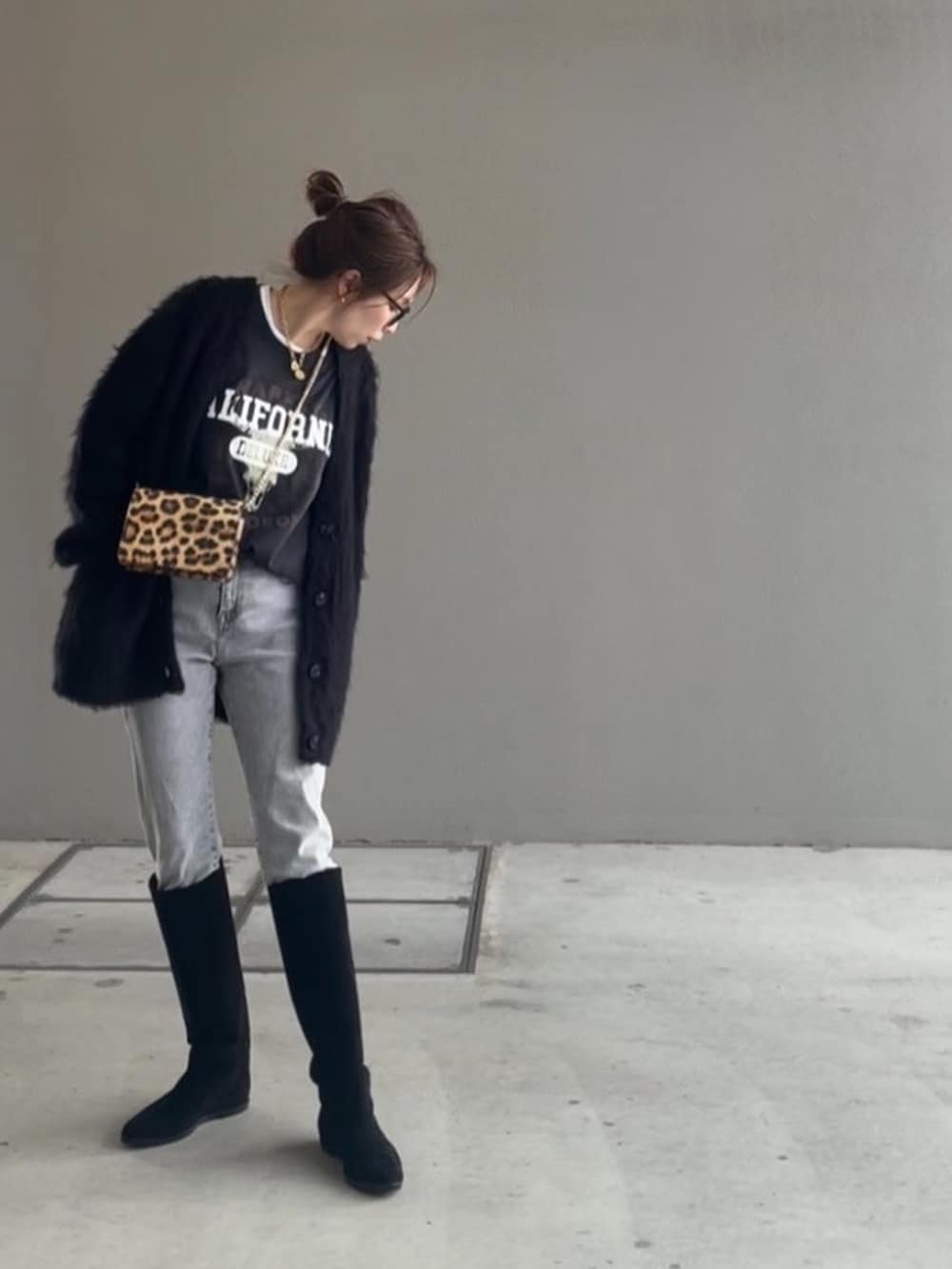 ブラック系のTシャツ/カットソー、ブラック系のカーディガン/ボレロ、ブラック系のブーツを着用したレディースの冬コーディネートの2枚目の写真