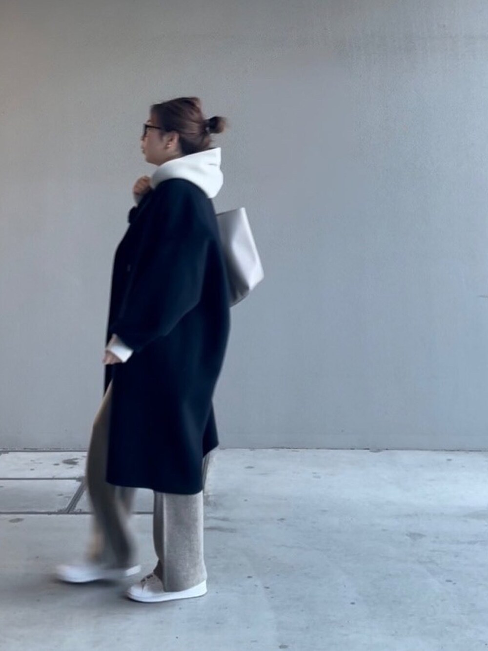 グレー系のトートバッグ、ベージュ系のパンツ、グレー系のTシャツ/カットソーを着用したレディースの冬コーディネートの2枚目の写真