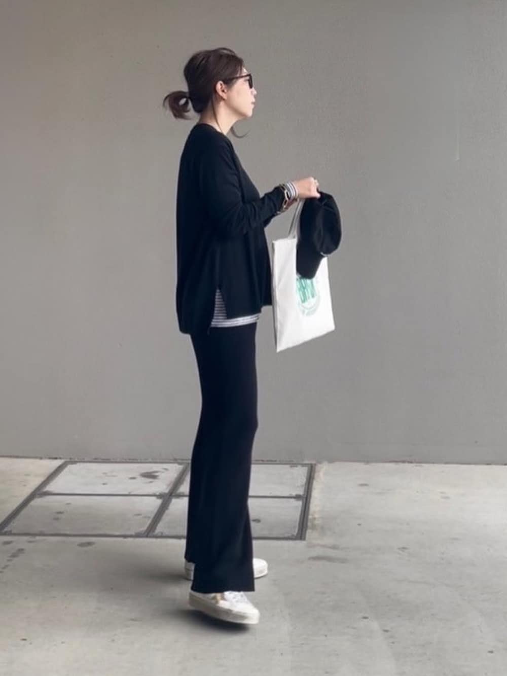 ブラック系のその他パンツ、ブラック系のニット/セーター、ホワイト系のTシャツ/カットソーを着用したレディースの秋コーディネートの2枚目の写真