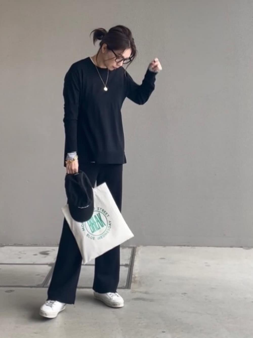 ブラック系のその他パンツ、ブラック系のニット/セーター、ホワイト系のTシャツ/カットソーを着用したレディースの秋コーディネートの3枚目の写真