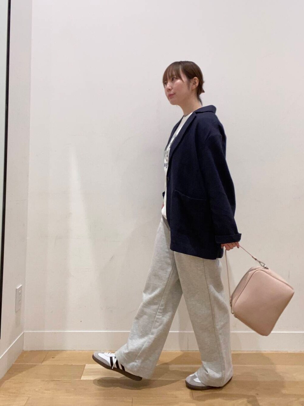 グレー系のその他パンツ、ピンク系のショルダーバッグ、ホワイト系のスニーカーを着用したレディースの春コーディネートの2枚目の写真