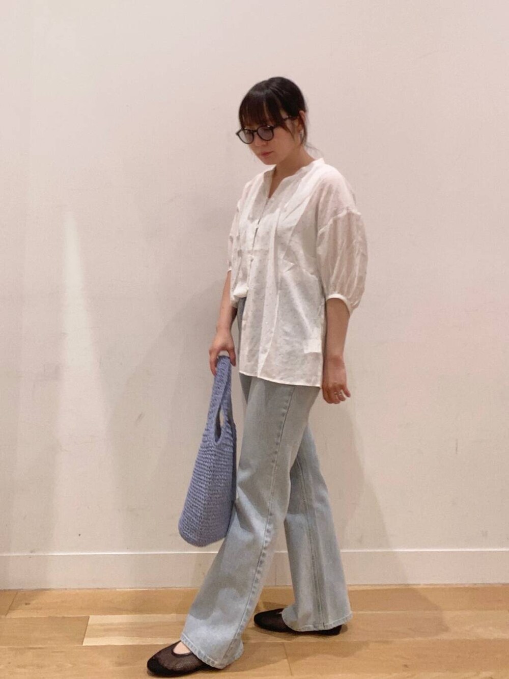 ブルー系のトートバッグ、ブルー系のデニムパンツ、ホワイト系のタンクトップを着用したレディースの夏コーディネートの3枚目の写真