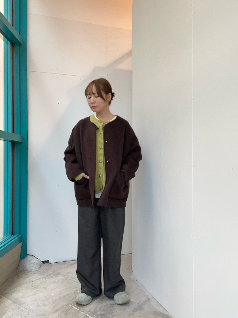 ブラウン系のその他アウター、グリーン系のカーディガン/ボレロ、ホワイト系のシャツ/ブラウスを着用したレディースの秋コーディネートの3枚目の写真