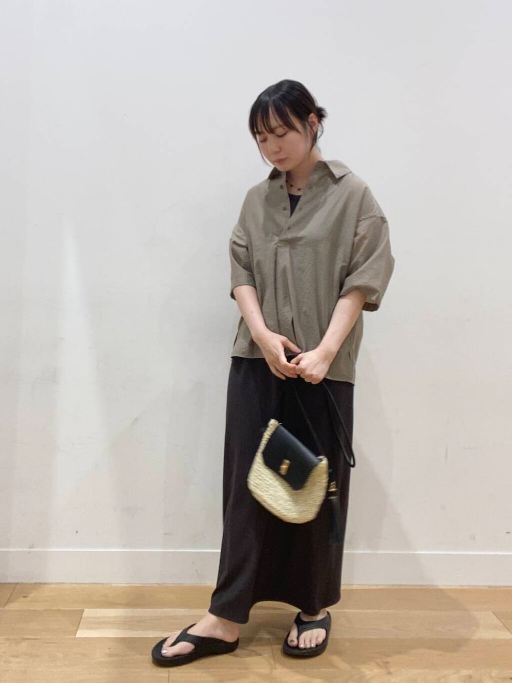 ベージュ系のショルダーバッグ、ブラック系のサンダル、ベージュ系のシャツ/ブラウスを着用したレディースの夏コーディネートの2枚目の写真