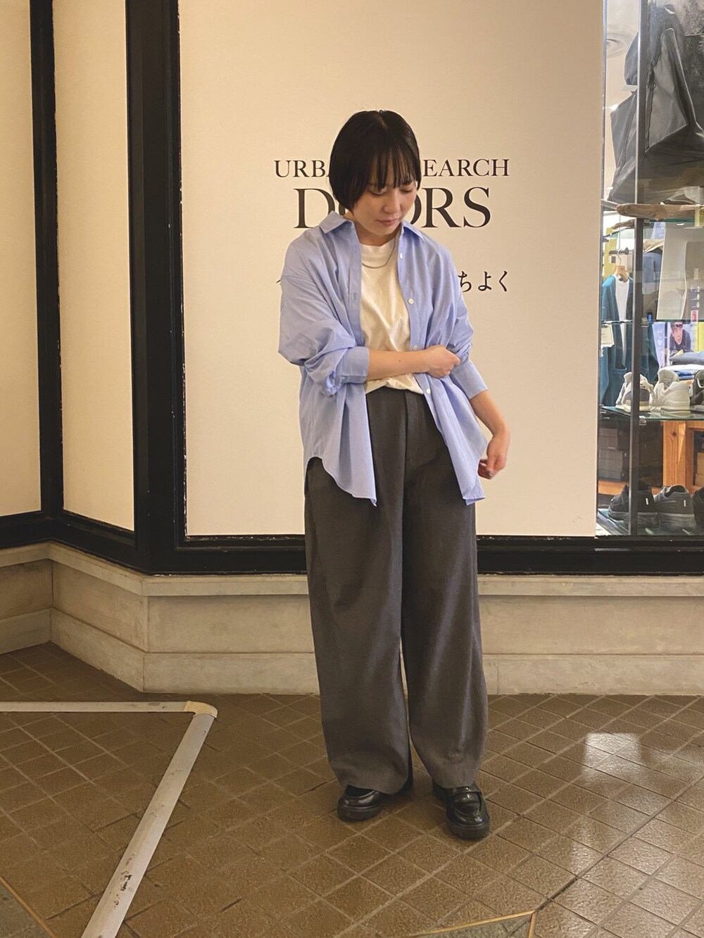 ブルー系のシャツ/ブラウス、グレー系のその他パンツ、ホワイト系のTシャツ/カットソーを着用したレディースの秋コーディネートの3枚目の写真