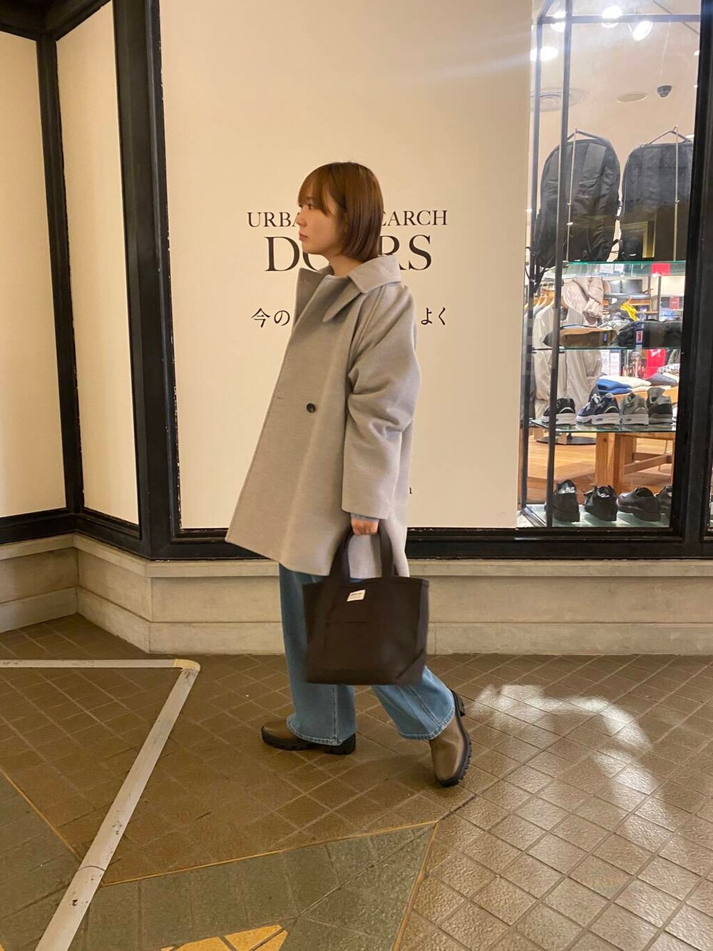 ブルー系のニット/セーター、ブラウン系のブーツ、グレー系のトートバッグを着用したレディースの冬コーディネートの5枚目の写真