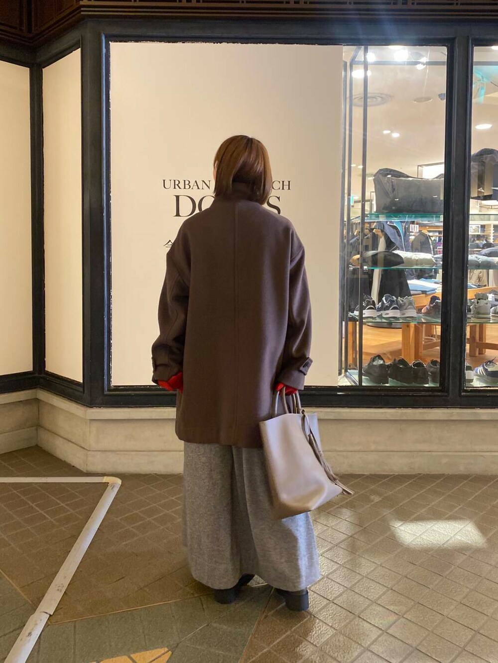 グレー系のトートバッグ、ブラウン系のブーツ、ブラウン系のその他アウターを着用したレディースの秋コーディネートの3枚目の写真