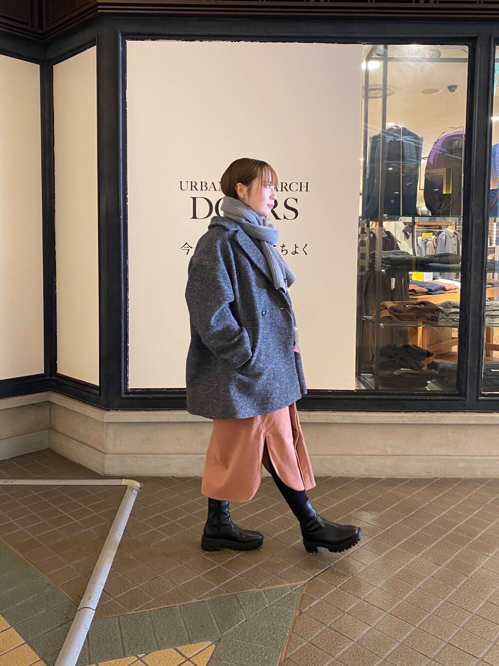 ブラック系のブーツ、グレー系のその他アウター、ピンク系のワンピースを着用したレディースの冬コーディネートの2枚目の写真