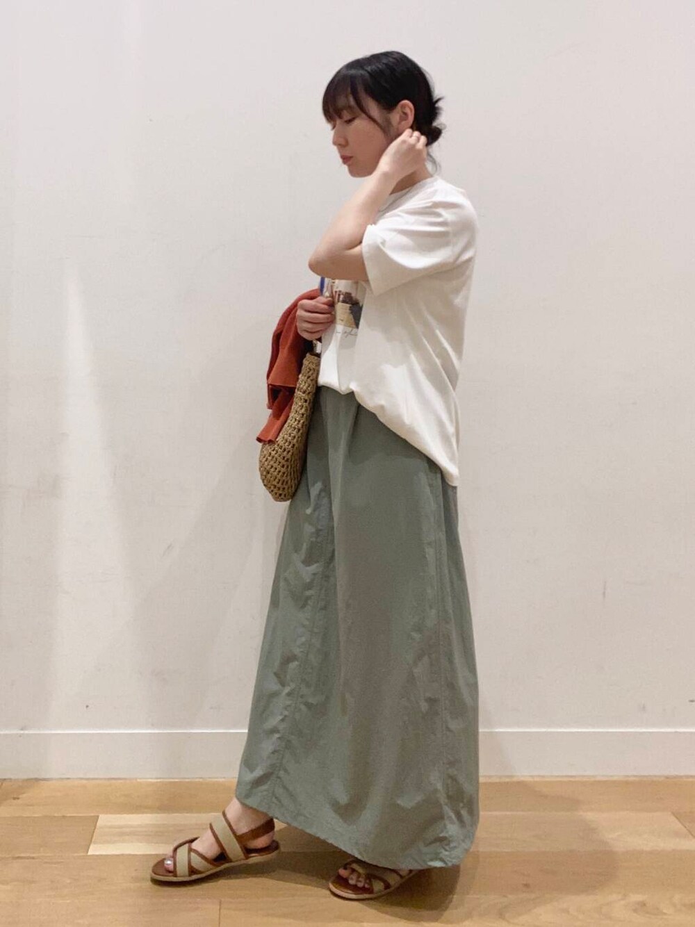 オレンジ系のカーディガン/ボレロ、ベージュ系のサンダル、ベージュ系のトートバッグを着用したレディースの夏コーディネートの6枚目の写真