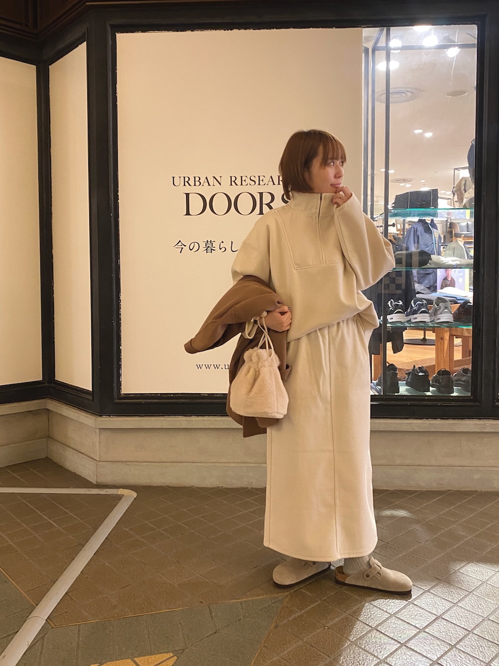 ホワイト系のTシャツ/カットソー、ホワイト系のスカート、ホワイト系のショルダーバッグを着用したレディースの秋コーディネートの5枚目の写真