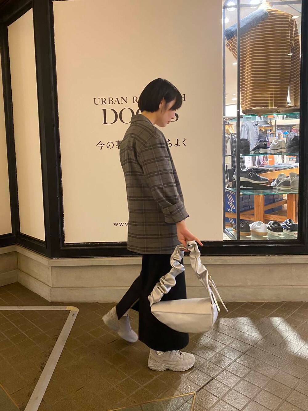 ホワイト系のTシャツ/カットソー、グレー系のスニーカー、シルバー系のハンドバッグを着用したレディースの秋コーディネートの3枚目の写真