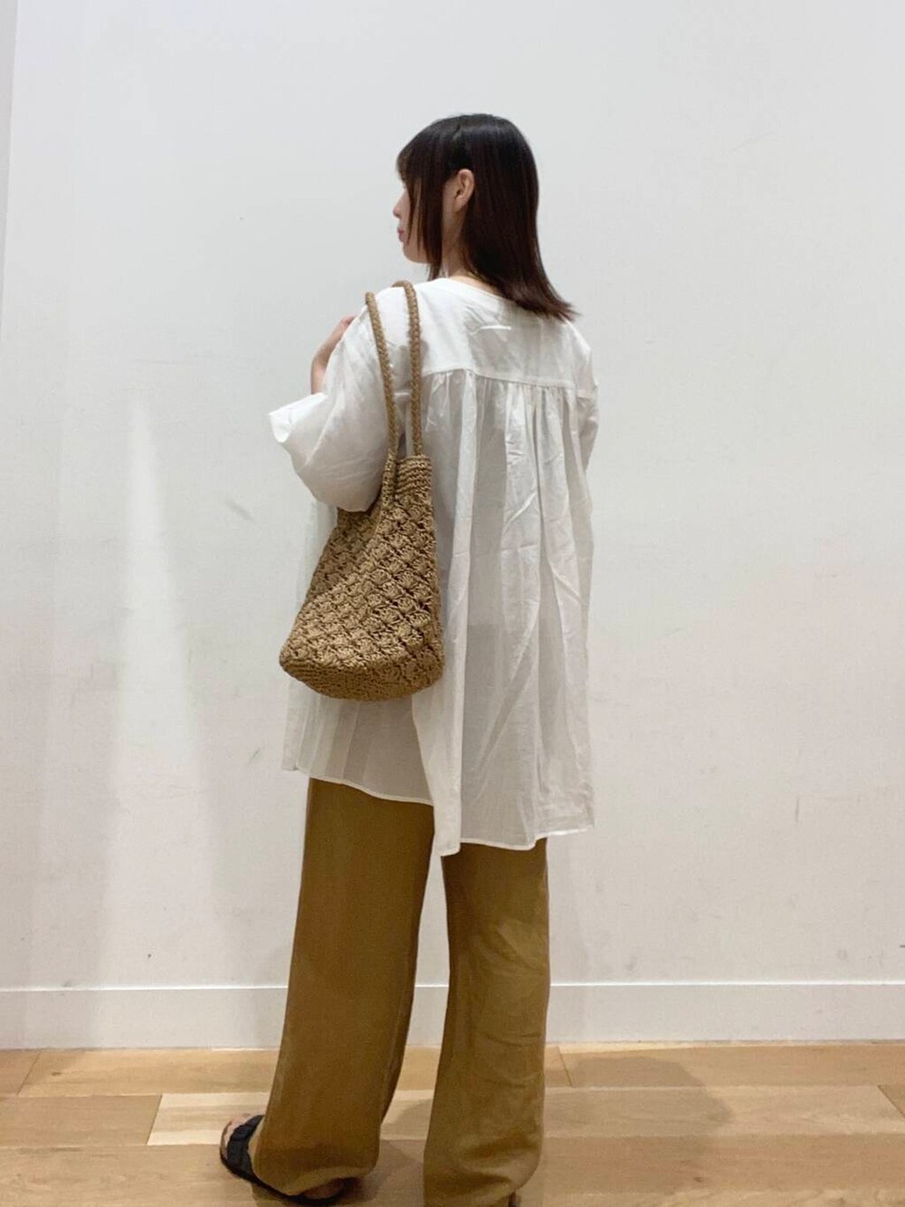 ベージュ系のタンクトップ、ベージュ系のトートバッグ、グレー系のサンダルを着用したレディースの夏コーディネートの4枚目の写真