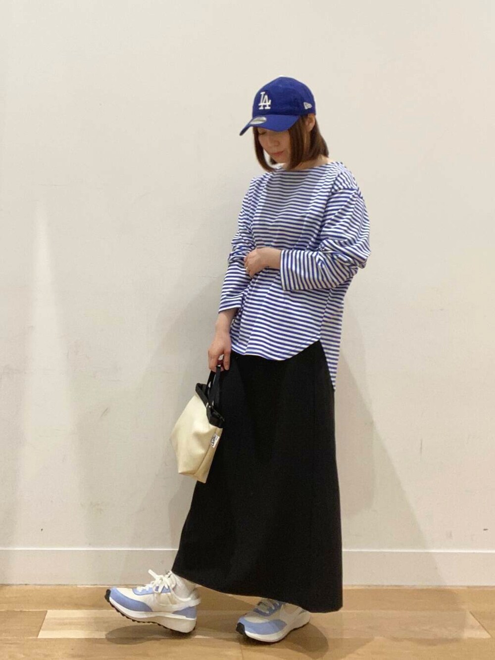 ブルー系のTシャツ/カットソー、ホワイト系のショルダーバッグ、ブルー系のスニーカーを着用したレディースの春コーディネートの2枚目の写真