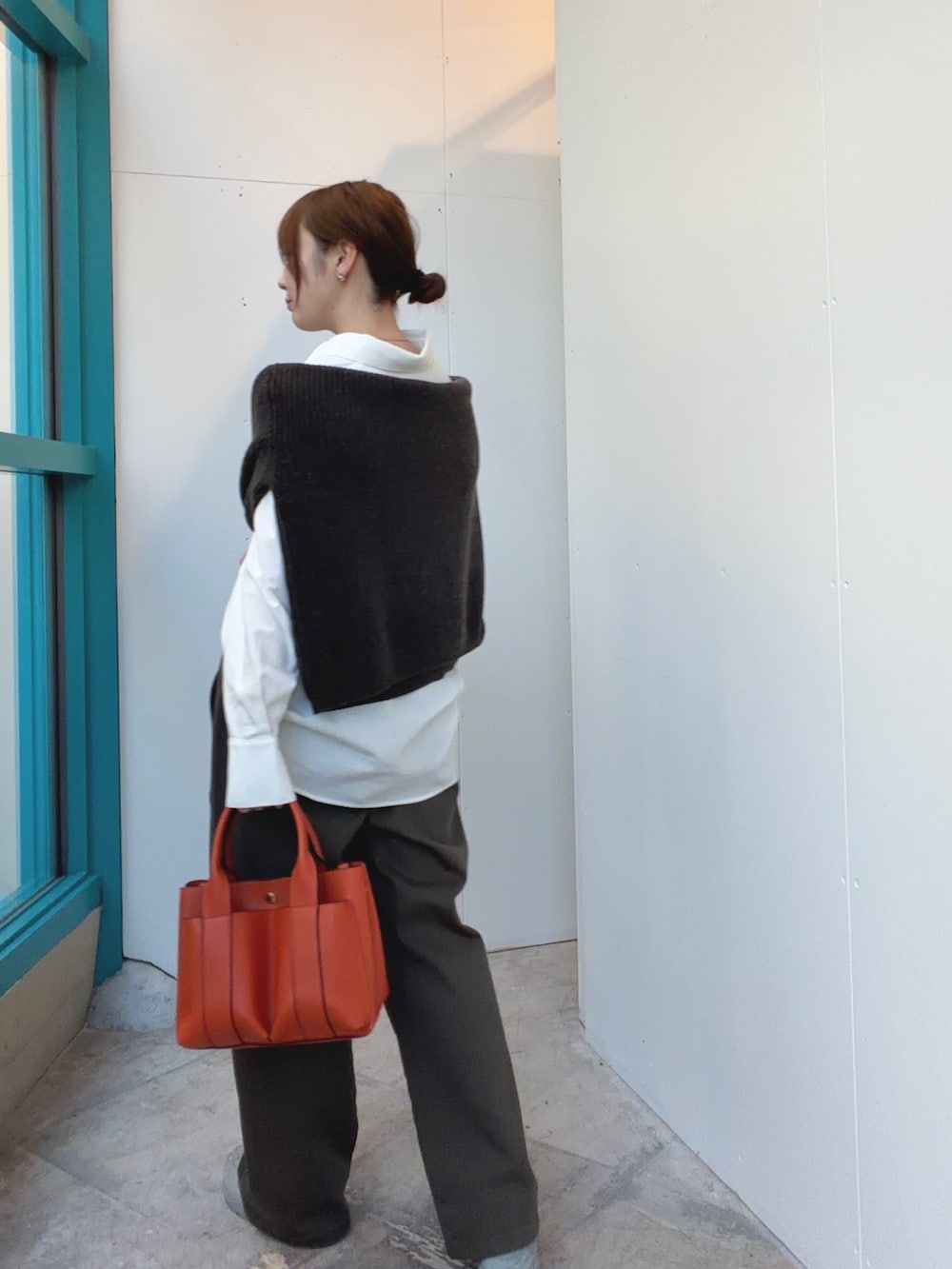 ブラウン系のニット/セーター、グリーン系のその他パンツ、ホワイト系のシャツ/ブラウスを着用したレディースの冬コーディネートの2枚目の写真