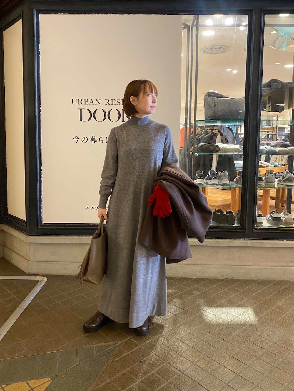 グレー系のトートバッグ、ブラウン系のブーツ、ブラウン系のその他アウターを着用したレディースの秋コーディネートの4枚目の写真