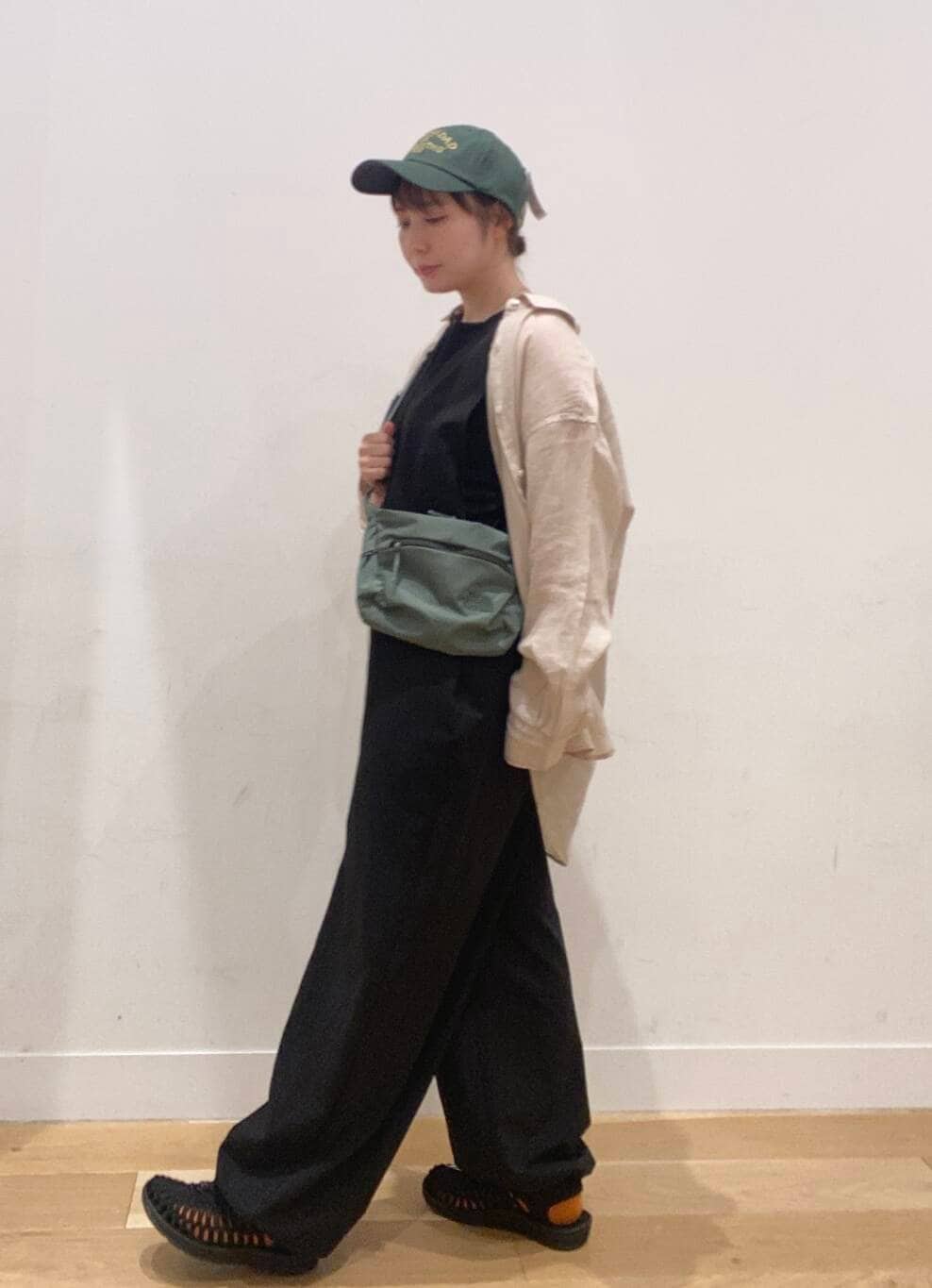 ブラック系のワンピース、ブラック系のタンクトップ、グリーン系のショルダーバッグを着用したレディースの夏コーディネートの3枚目の写真