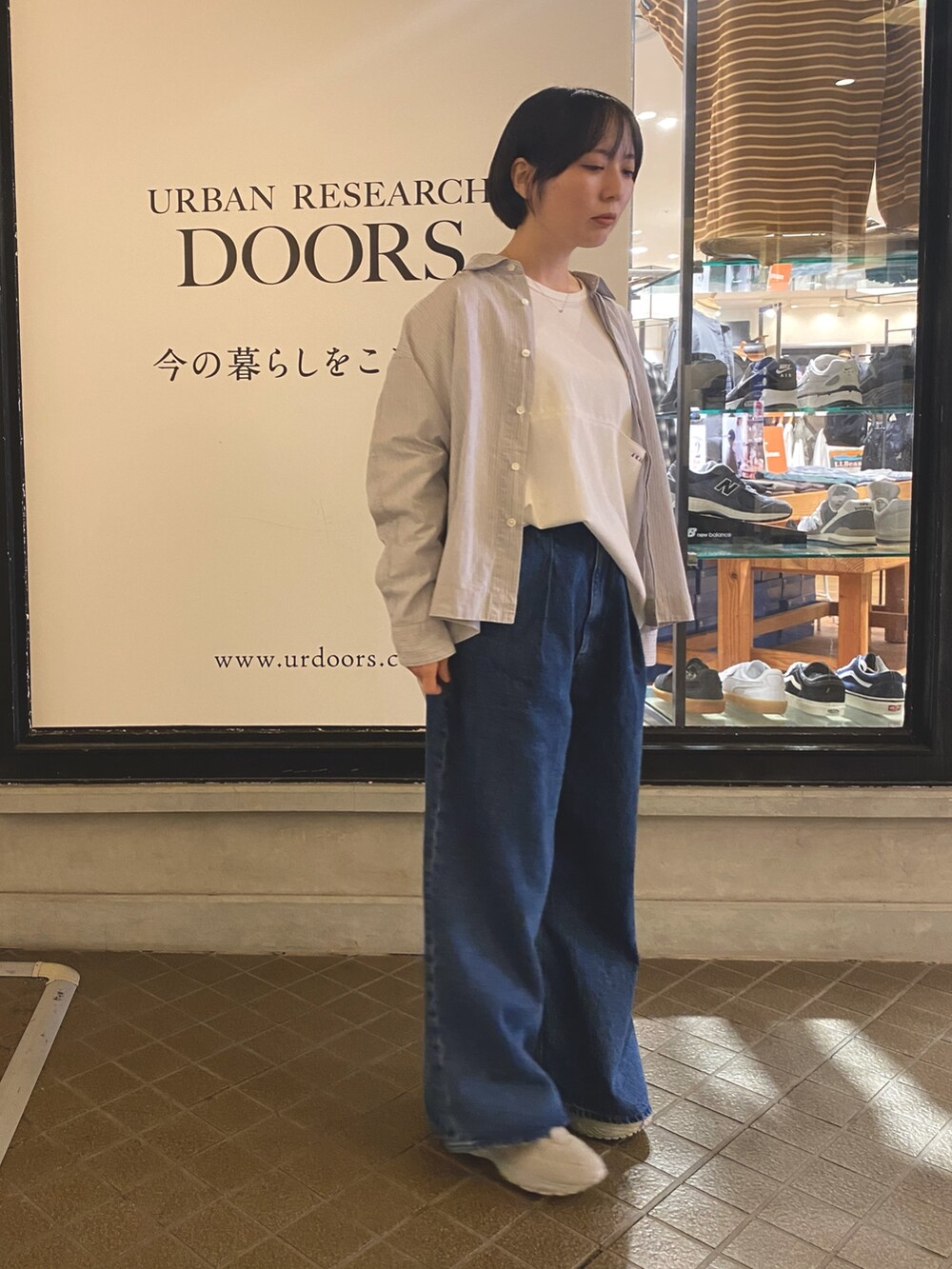 ブルー系のデニムパンツ、ホワイト系のTシャツ/カットソー、グレー系のシャツ/ブラウスを着用したレディースの秋コーディネートの3枚目の写真