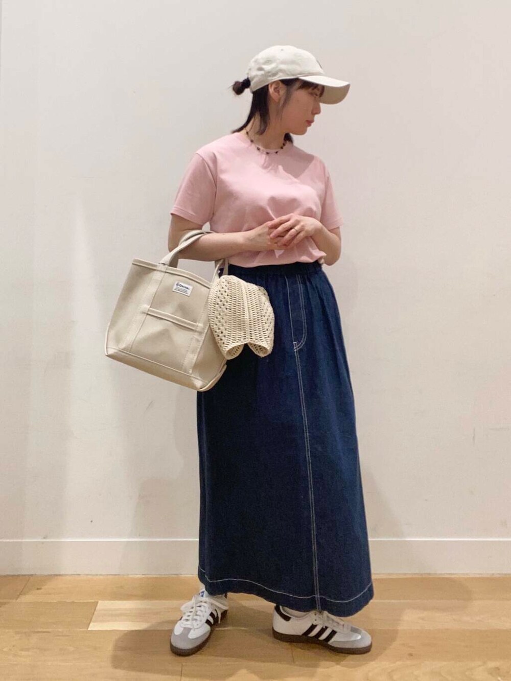 ホワイト系のスニーカー、ピンク系のTシャツ/カットソー、ブルー系のスカートを着用したレディースの春コーディネートの4枚目の写真
