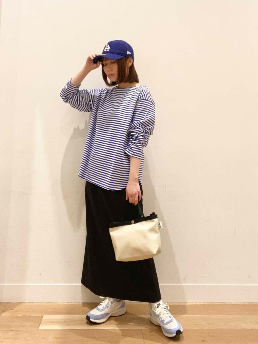 ブルー系のTシャツ/カットソー、ホワイト系のショルダーバッグ、ブルー系のスニーカーを着用したレディースの春コーディネートの3枚目の写真