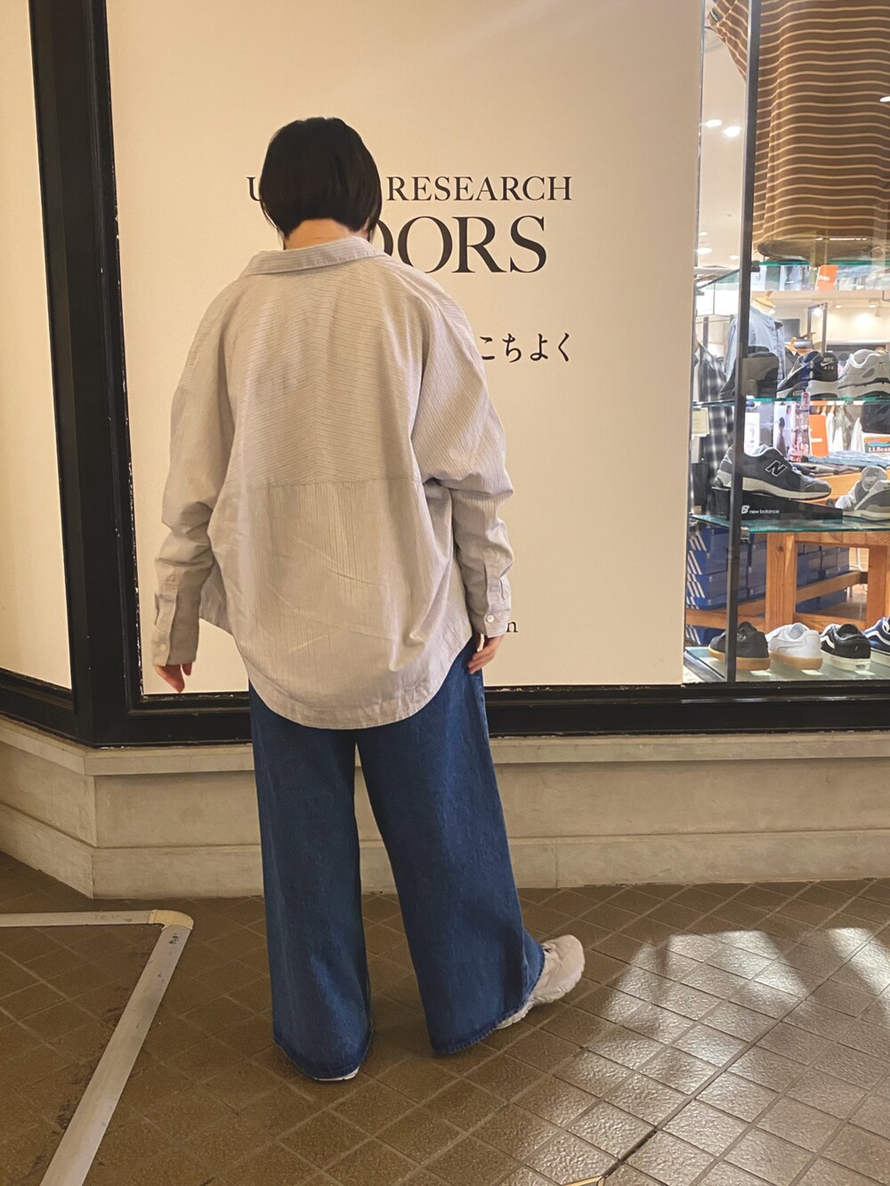 ブルー系のデニムパンツ、ホワイト系のTシャツ/カットソー、グレー系のシャツ/ブラウスを着用したレディースの秋コーディネートの2枚目の写真