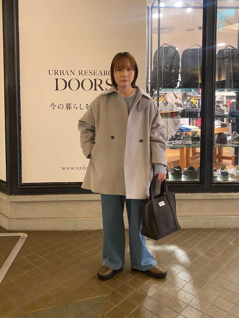 ブルー系のニット/セーター、ブラウン系のブーツ、グレー系のトートバッグを着用したレディースの冬コーディネートの4枚目の写真