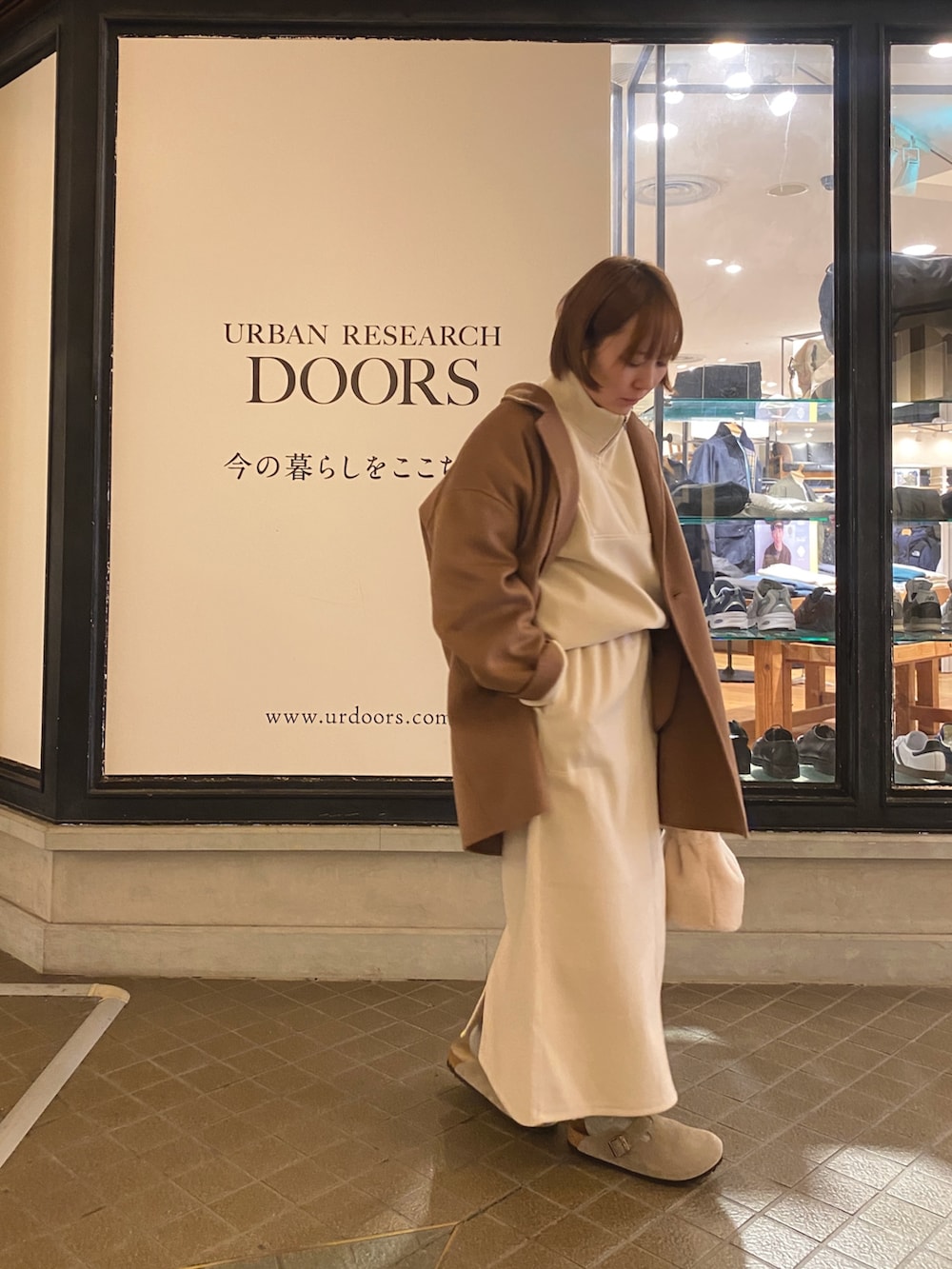 ホワイト系のTシャツ/カットソー、ホワイト系のスカート、ホワイト系のショルダーバッグを着用したレディースの秋コーディネートの2枚目の写真