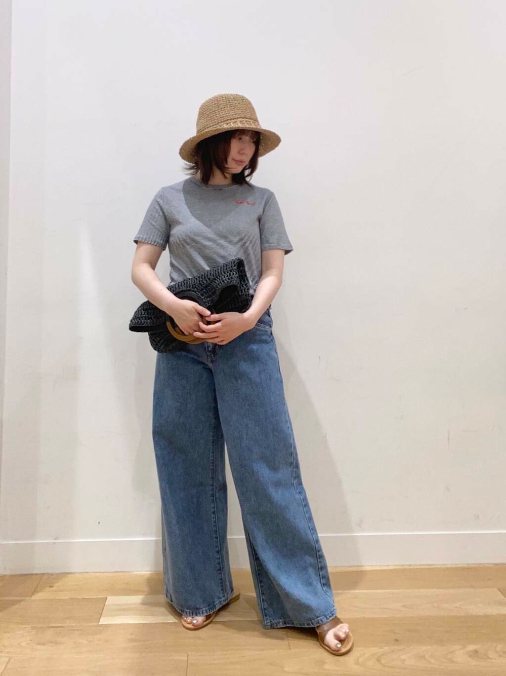 ブラウン系のサンダル、ブラック系のトートバッグ、ブルー系のTシャツ/カットソーを着用したレディースの春コーディネートの3枚目の写真