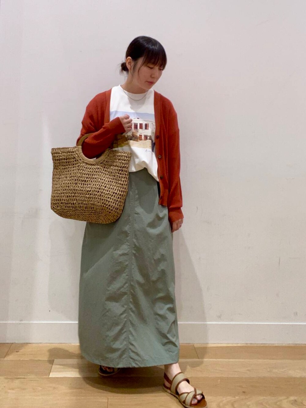 オレンジ系のカーディガン/ボレロ、ベージュ系のサンダル、ベージュ系のトートバッグを着用したレディースの夏コーディネートの3枚目の写真