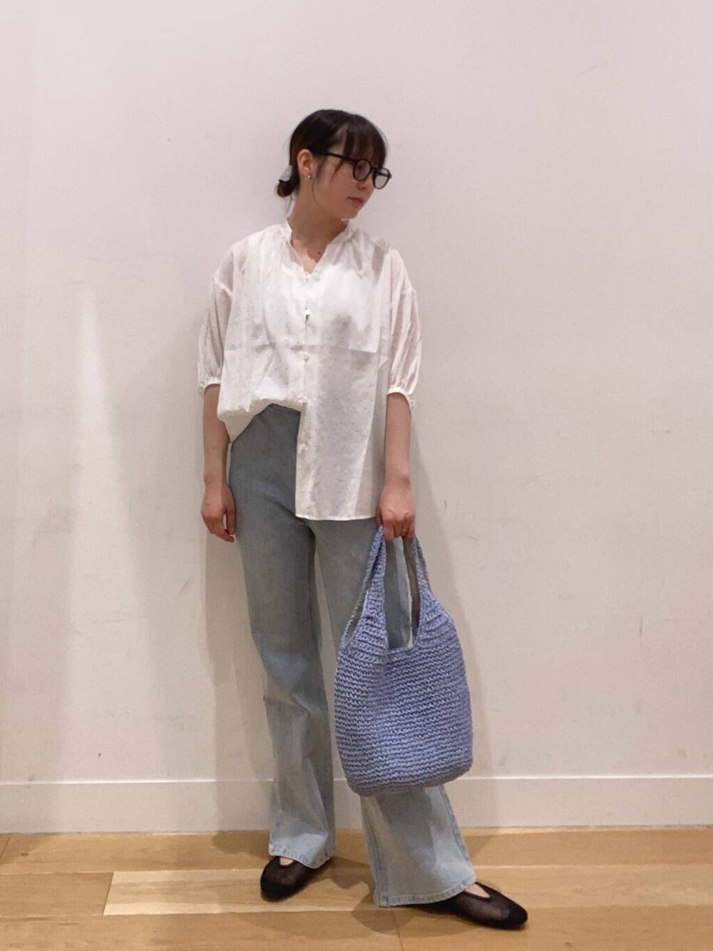 ブルー系のトートバッグ、ブルー系のデニムパンツ、ホワイト系のタンクトップを着用したレディースの夏コーディネートの4枚目の写真