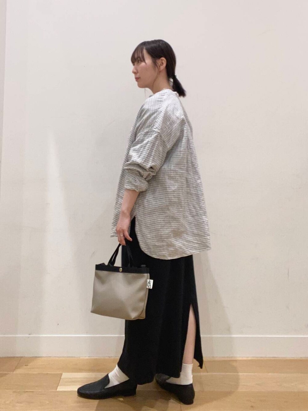 ブラック系のドレスシューズ、ホワイト系のシャツ/ブラウス、グレー系のショルダーバッグを着用したレディースの春コーディネートの2枚目の写真