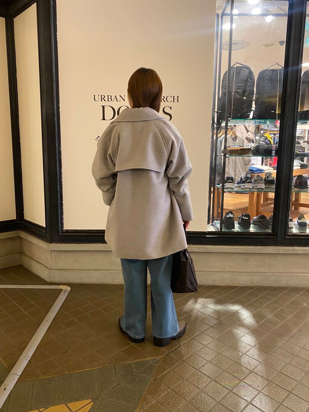 ブルー系のニット/セーター、ブラウン系のブーツ、グレー系のトートバッグを着用したレディースの冬コーディネートの6枚目の写真