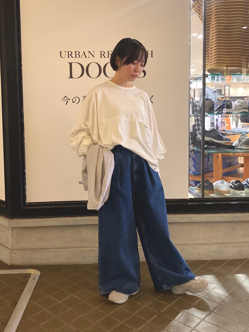 ブルー系のデニムパンツ、ホワイト系のTシャツ/カットソー、グレー系のシャツ/ブラウスを着用したレディースの秋コーディネートの4枚目の写真