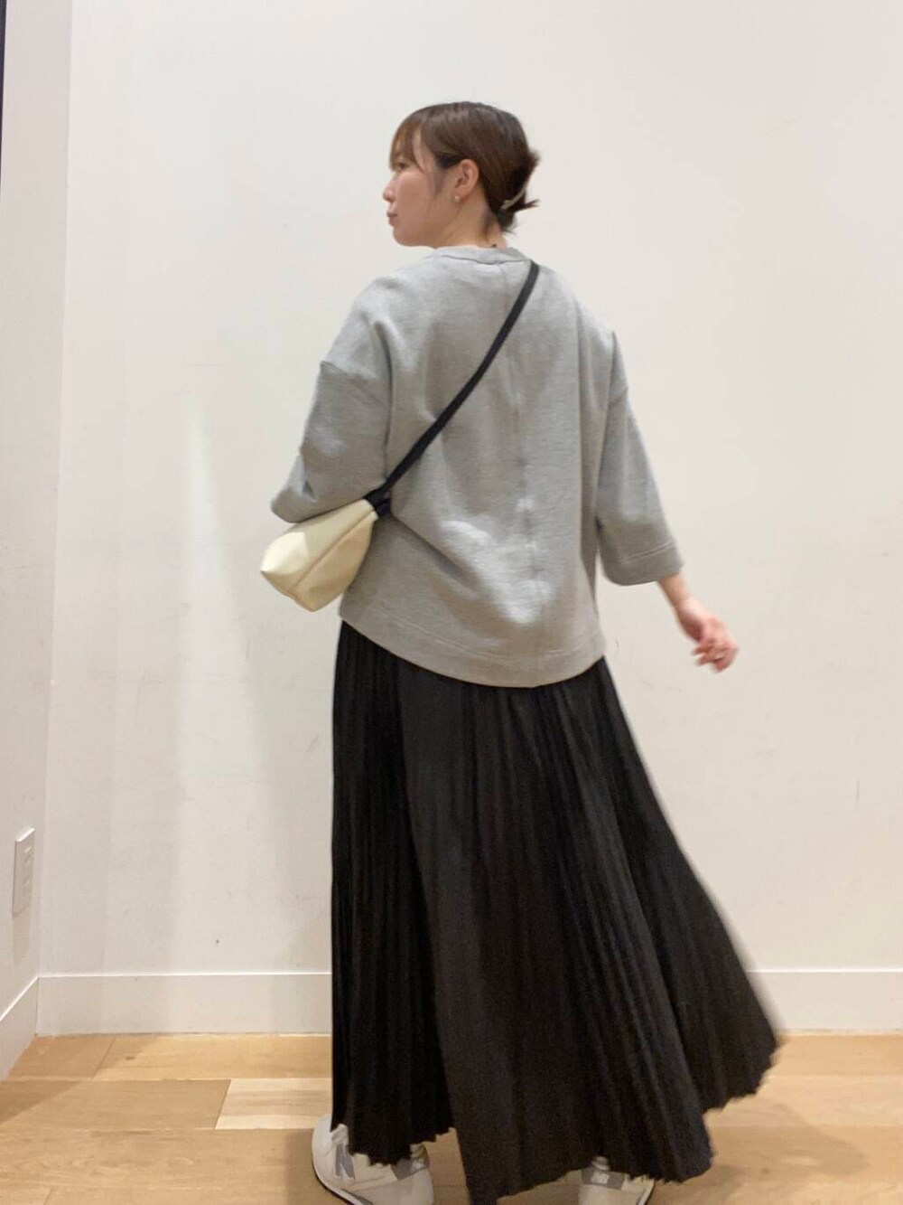ブラック系のスカート、ベージュ系のスニーカー、グレー系のスウェットを着用したレディースの春コーディネートの5枚目の写真