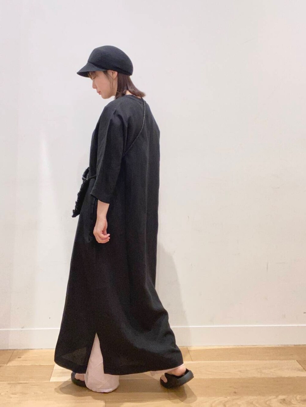 ブラック系のワンピース、ブラック系のサンダル、ブラック系のショルダーバッグを着用したレディースの春コーディネートの5枚目の写真