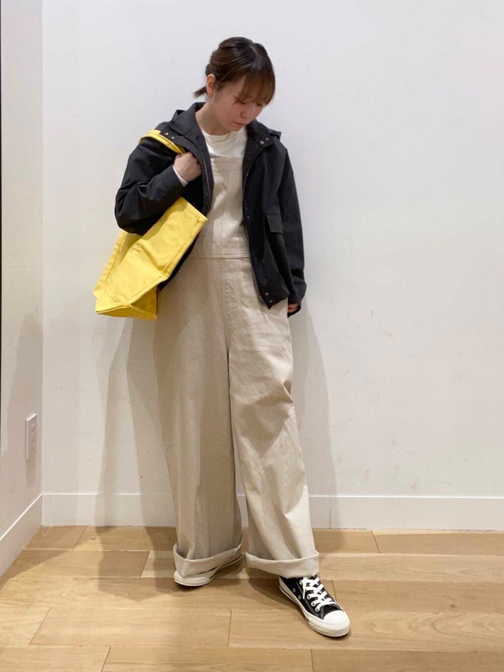 グレー系のマウンテンパーカー、ベージュ系のサロペット/オーバーオール、ホワイト系のTシャツ/カットソーを着用したレディースの春コーディネートの2枚目の写真