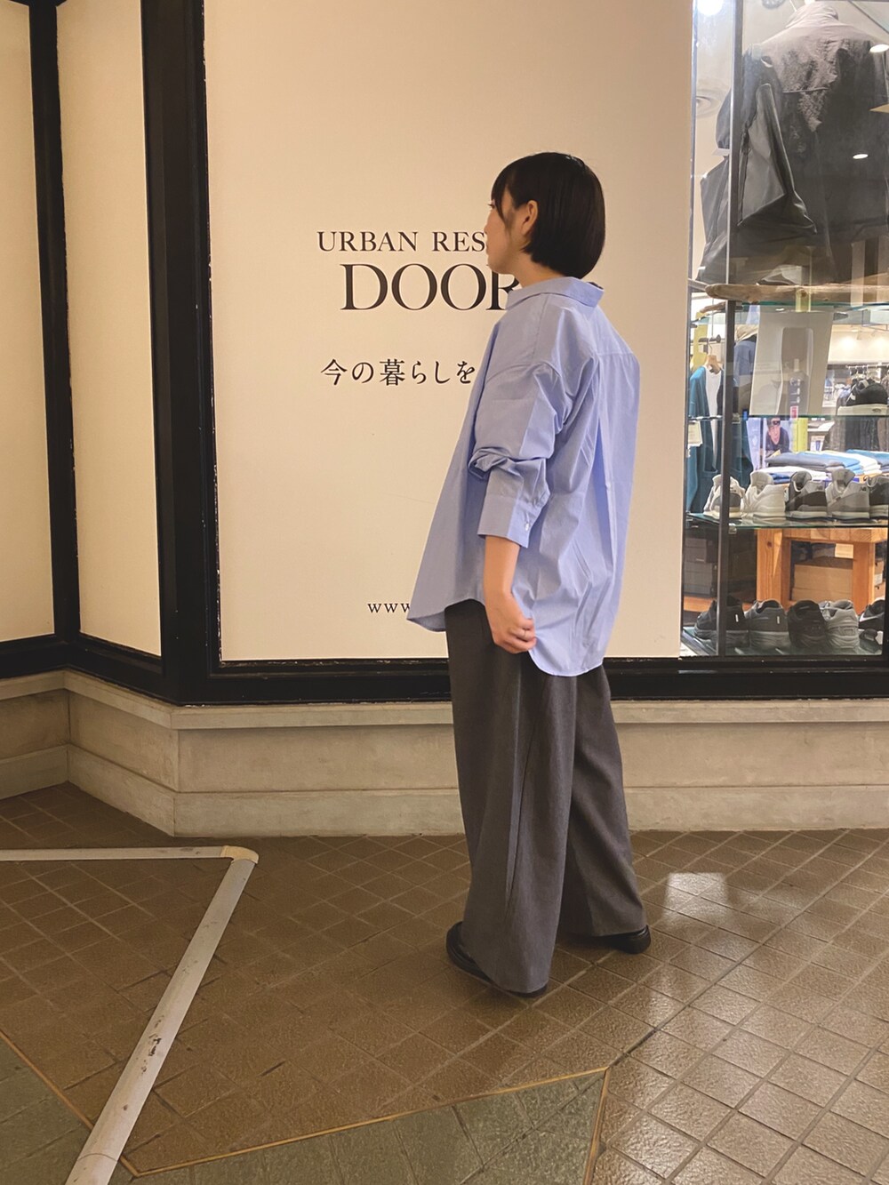 ブルー系のシャツ/ブラウス、グレー系のその他パンツ、ホワイト系のTシャツ/カットソーを着用したレディースの秋コーディネートの2枚目の写真