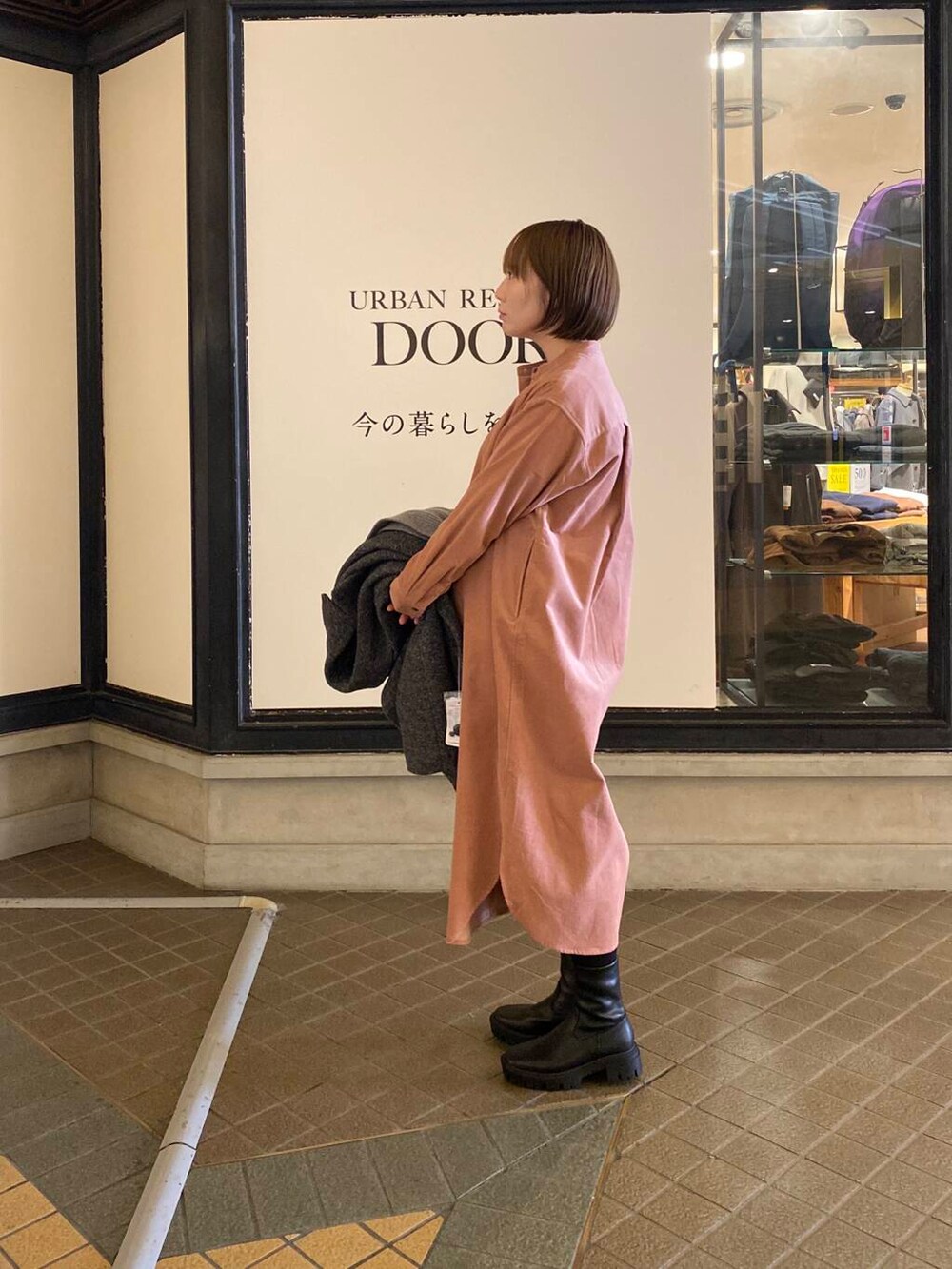 ブラック系のブーツ、グレー系のその他アウター、ピンク系のワンピースを着用したレディースの冬コーディネートの6枚目の写真