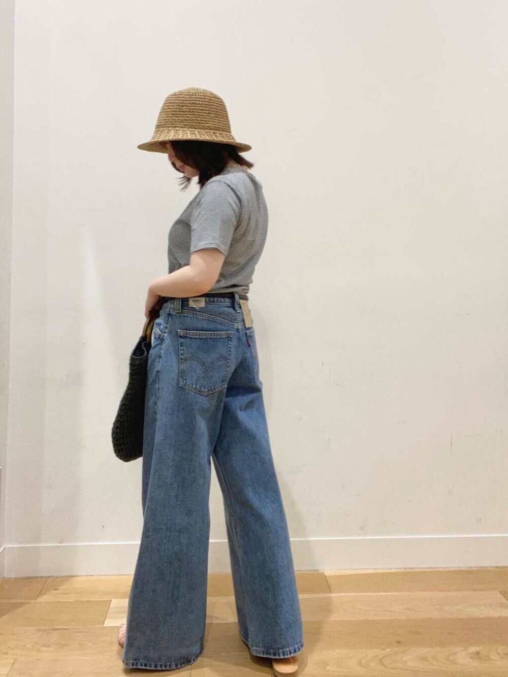 ブラウン系のサンダル、ブラック系のトートバッグ、ブルー系のTシャツ/カットソーを着用したレディースの春コーディネートの2枚目の写真