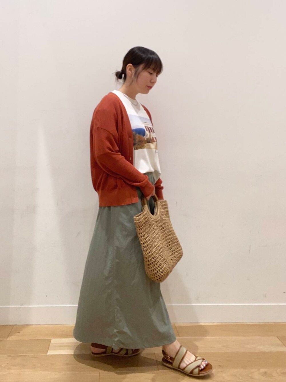 オレンジ系のカーディガン/ボレロ、ベージュ系のサンダル、ベージュ系のトートバッグを着用したレディースの夏コーディネートの2枚目の写真
